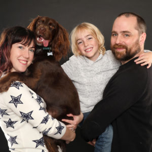 family photoshoot smiling couple with young son and family dog