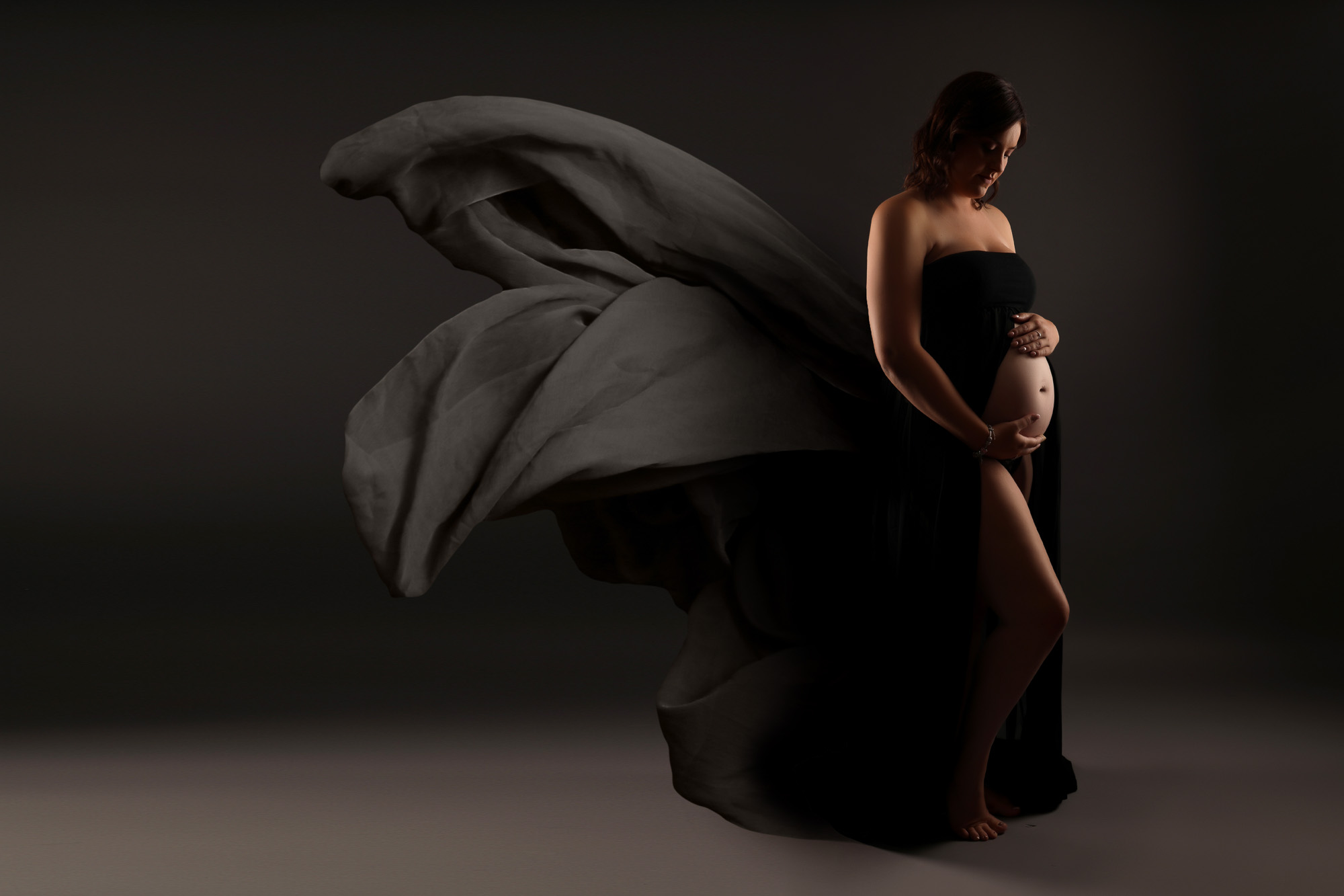 bump to baby photoshoot liverpool pregnant woman in flowing black maternity gown holding bump
