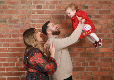 Family Portrait Photoshoot Peekaboo Liverpool couple with laughing toddler