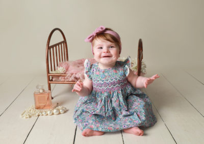 Little sitters baby toddler Photoshoot Peekaboo Liverpool little girl sitting near vintage mini bed frame prop
