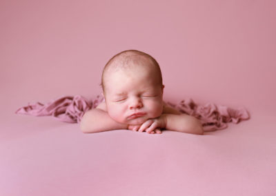 Newborn photoshoot Peekaboo Liverpool sleeping baby pink backbround