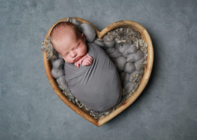 Newborn photoshoot Peekaboo Liverpool grey heart on grey backdrop