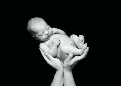 Newborn photoshoot Peekaboo Liverpool black and white hands holding baby