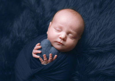 Newborn photoshoot Peekaboo Liverpool baby boy holding deep blue heart