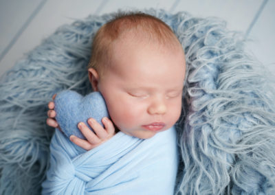 Newborn photoshoot Peekaboo Liverpool baby boy holding blue heart
