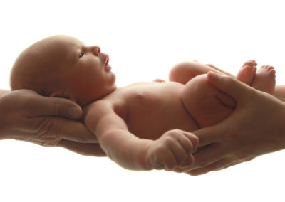 Newborn photoshoot Peekaboo Liverpool parents hands cradling baby backlit